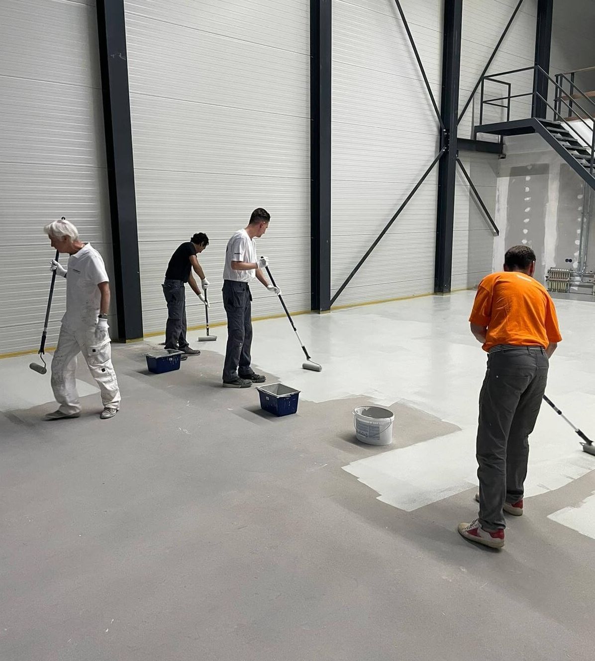 Medewerkers schilderen de vloer op de eerste etage